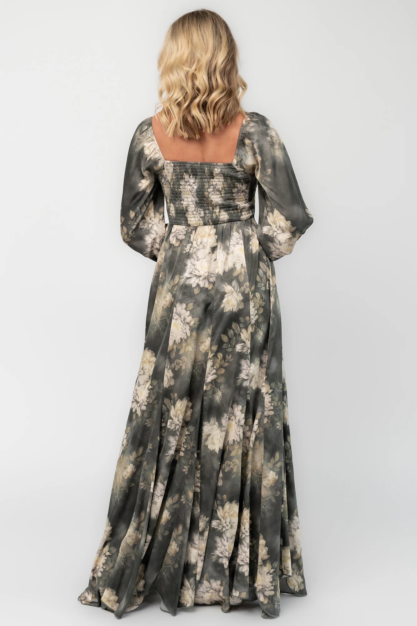 Dark sage floral maxi dress with a V-neck twist knot, half sleeves, smocked back waist, paneled empire waist, and flowing scalloped asymmetrical hem.