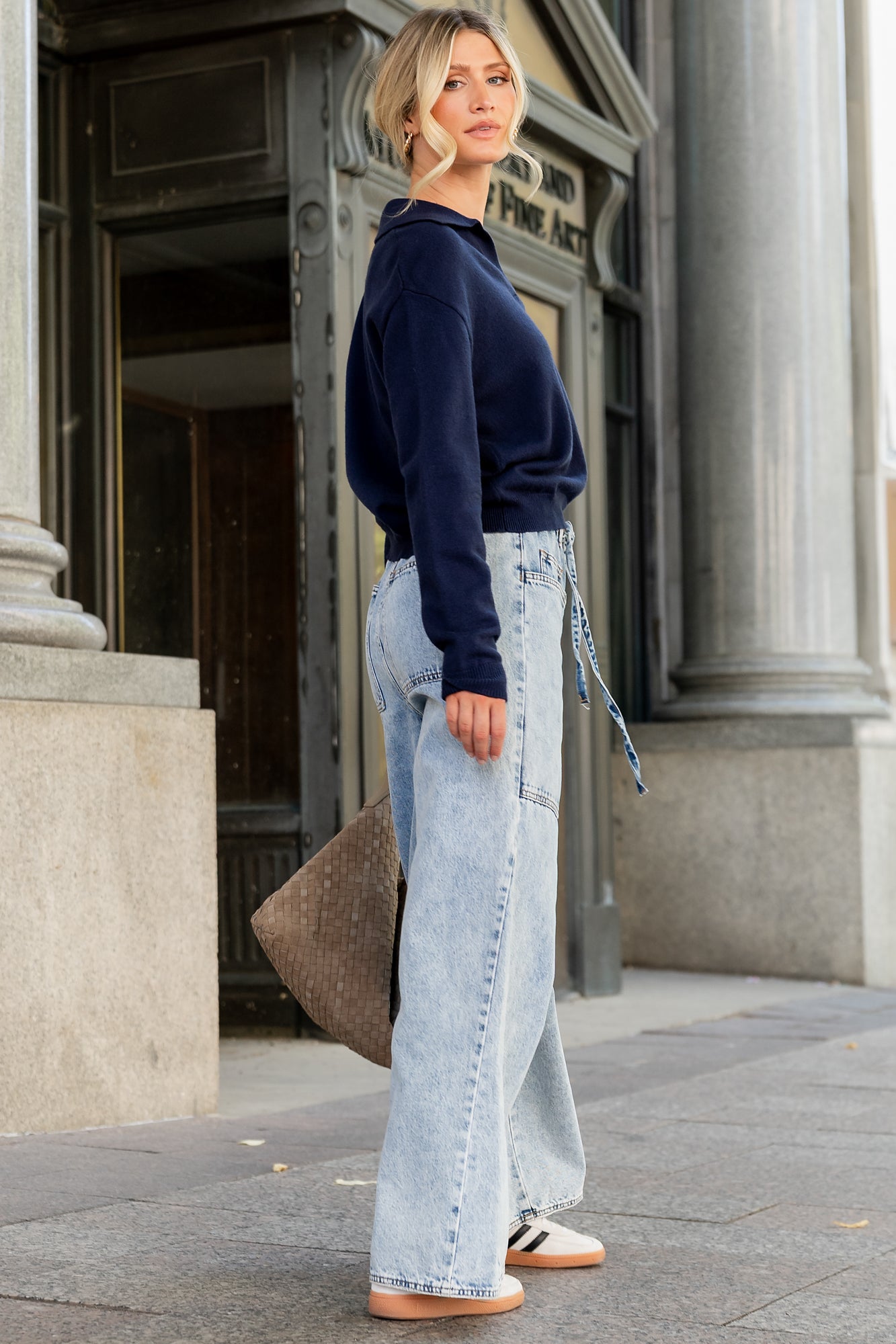 Product flat-lay of navy Bodhi sweater showing collar shape, ribbed hem, and overall relaxed proportions for size comparison.