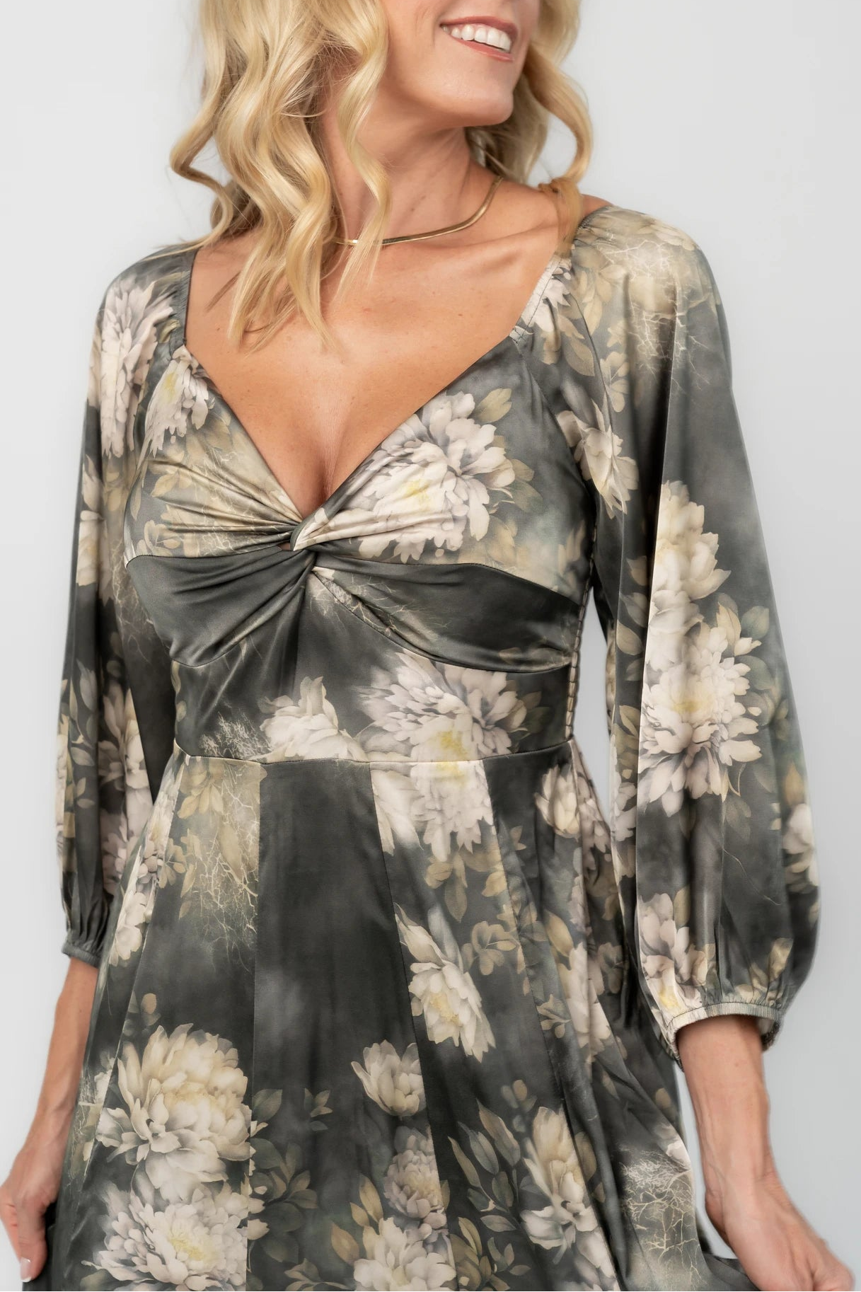 Dark sage floral maxi dress with a V-neck twist knot, half sleeves, smocked back waist, paneled empire waist, and flowing scalloped asymmetrical hem.