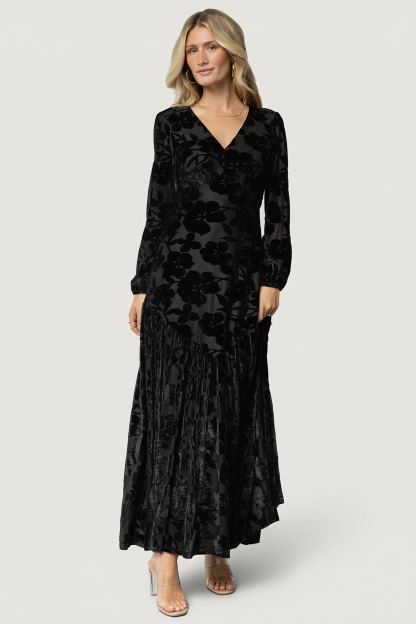 Full-length front view of black burnout velvet maxi dress showing V-neckline, fitted bodice, and flowing floral skirt for evening wear.