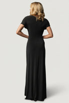Full-length image of the black Annaeli dress on model walking to show the skirt's movement and relaxed, event-ready silhouette.