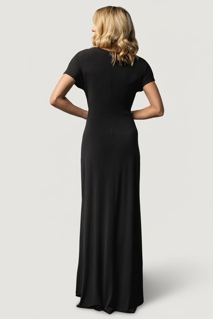 Full-length image of the black Annaeli dress on model walking to show the skirt's movement and relaxed, event-ready silhouette.