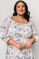 Styled flat-lay of Marta Smocked Midi Dress fabric and pattern showing blue floral print and lightweight polyester weave.