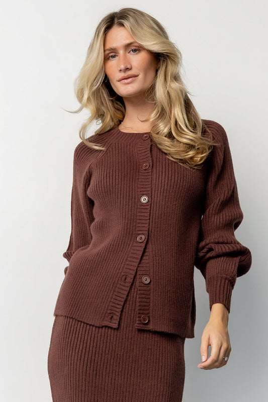 Front model view of the Blair mahogany rib knit cardigan showing three-button front, ribbed cuffs and hem, and a relaxed mid-length silhouette.