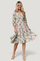 Styled outfit image of the multi floral smocked midi dress paired with casual sandals to show event-ready styling options.