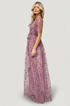 Model wearing lavender Marseille maxi dress showing crossover surplice bodice, short unlined sleeves, and inverted lining seam.