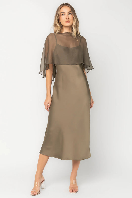 Olive satin midi dress with an attached sheer chiffon cape overlay, round neckline, hidden side zipper, and elegant slip silhouette.