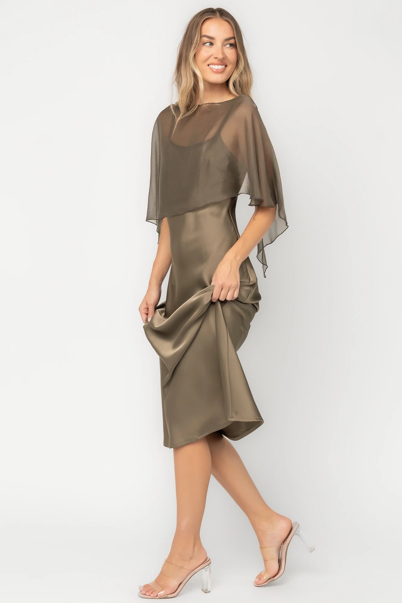 Olive satin midi dress with an attached sheer chiffon cape overlay, round neckline, hidden side zipper, and elegant slip silhouette.