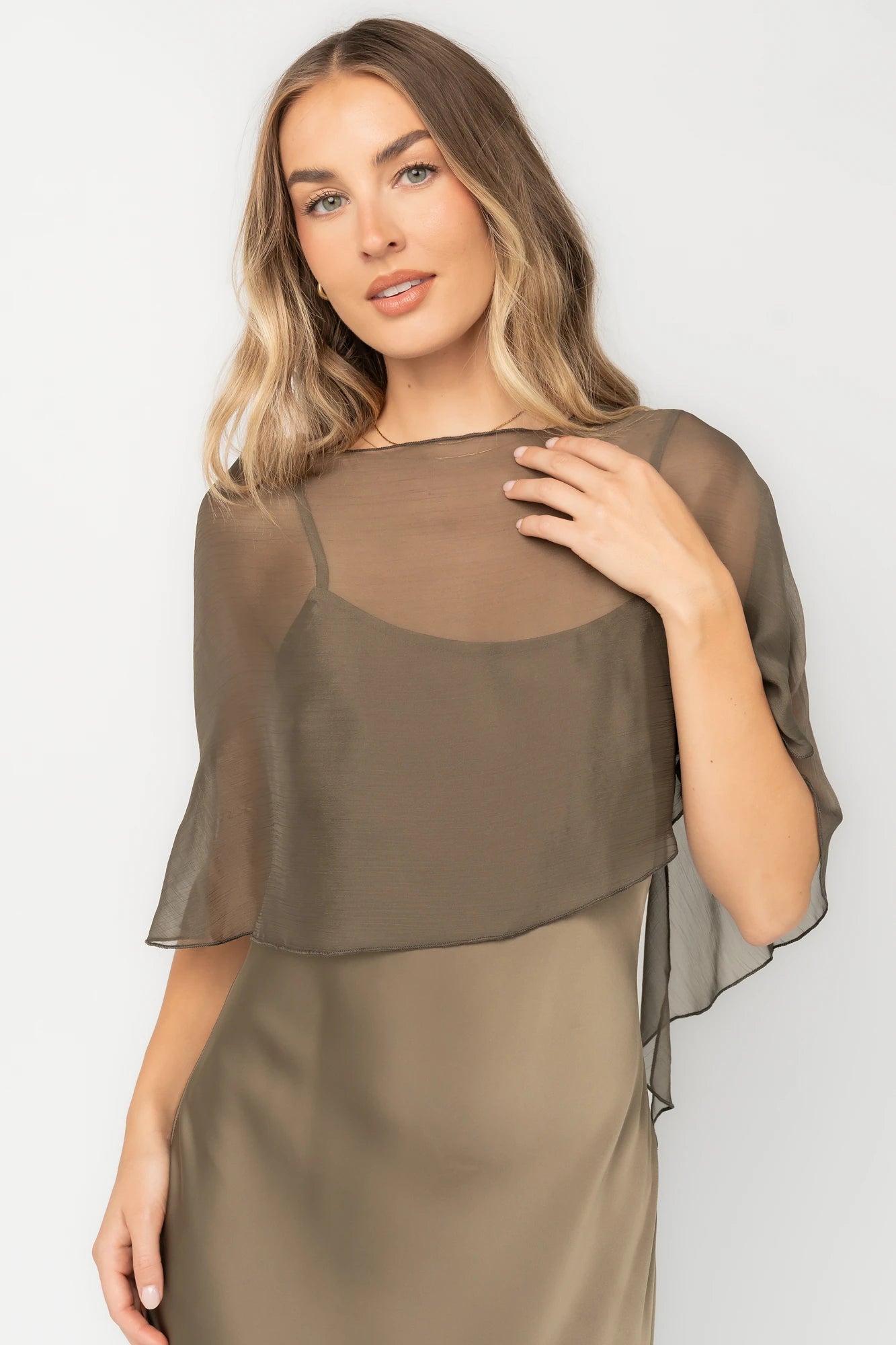 Olive satin midi dress with an attached sheer chiffon cape overlay, round neckline, hidden side zipper, and elegant slip silhouette.