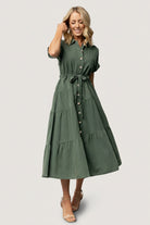 Three-quarter view of the washed green Logan Button Up Dress highlighting A-line tiered maxi skirt, diagonal seam detail, and lightweight unlined construction.