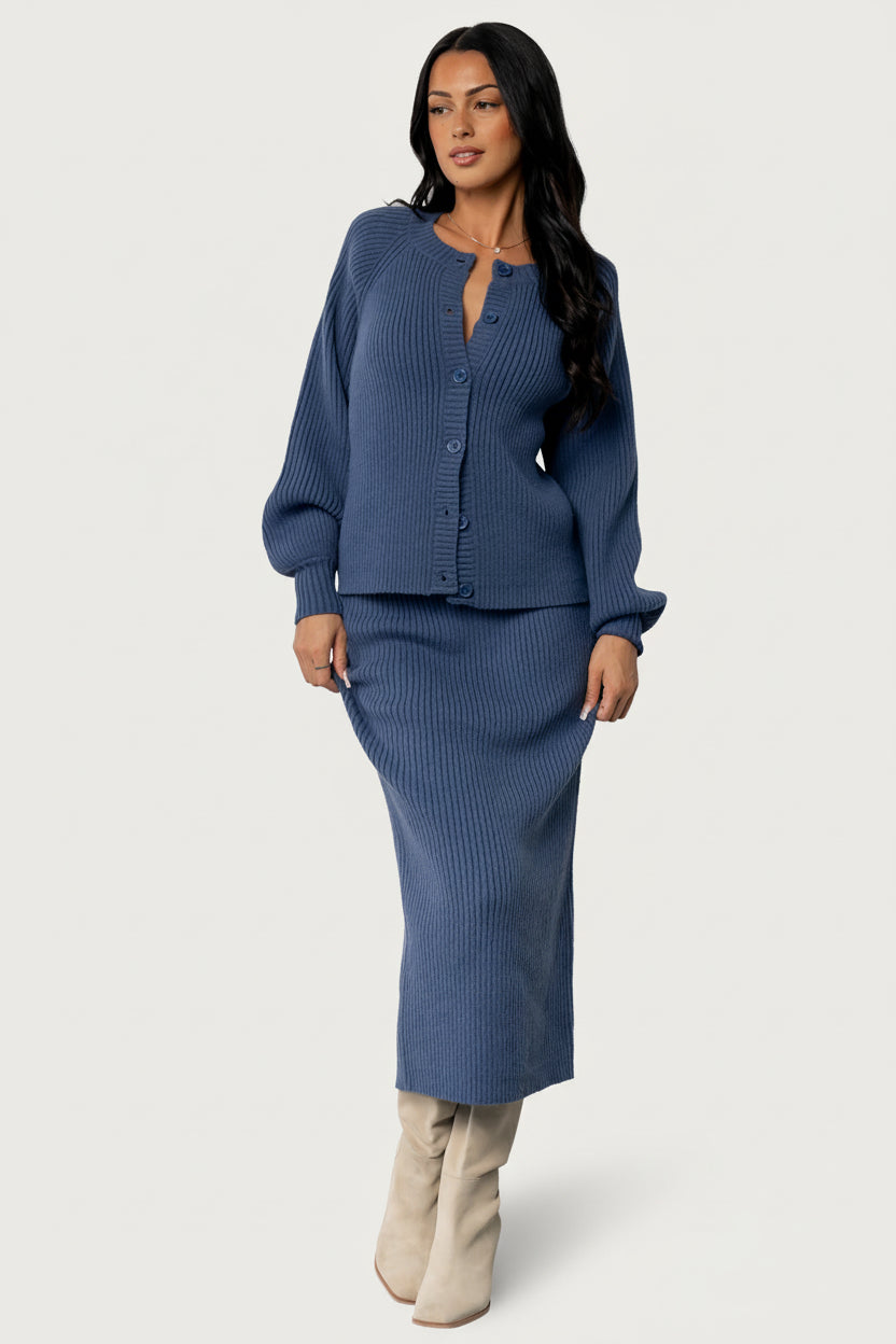 Close-up detail of the cardigan's ribbed knit fabric and three functional blue buttons on the front placket.