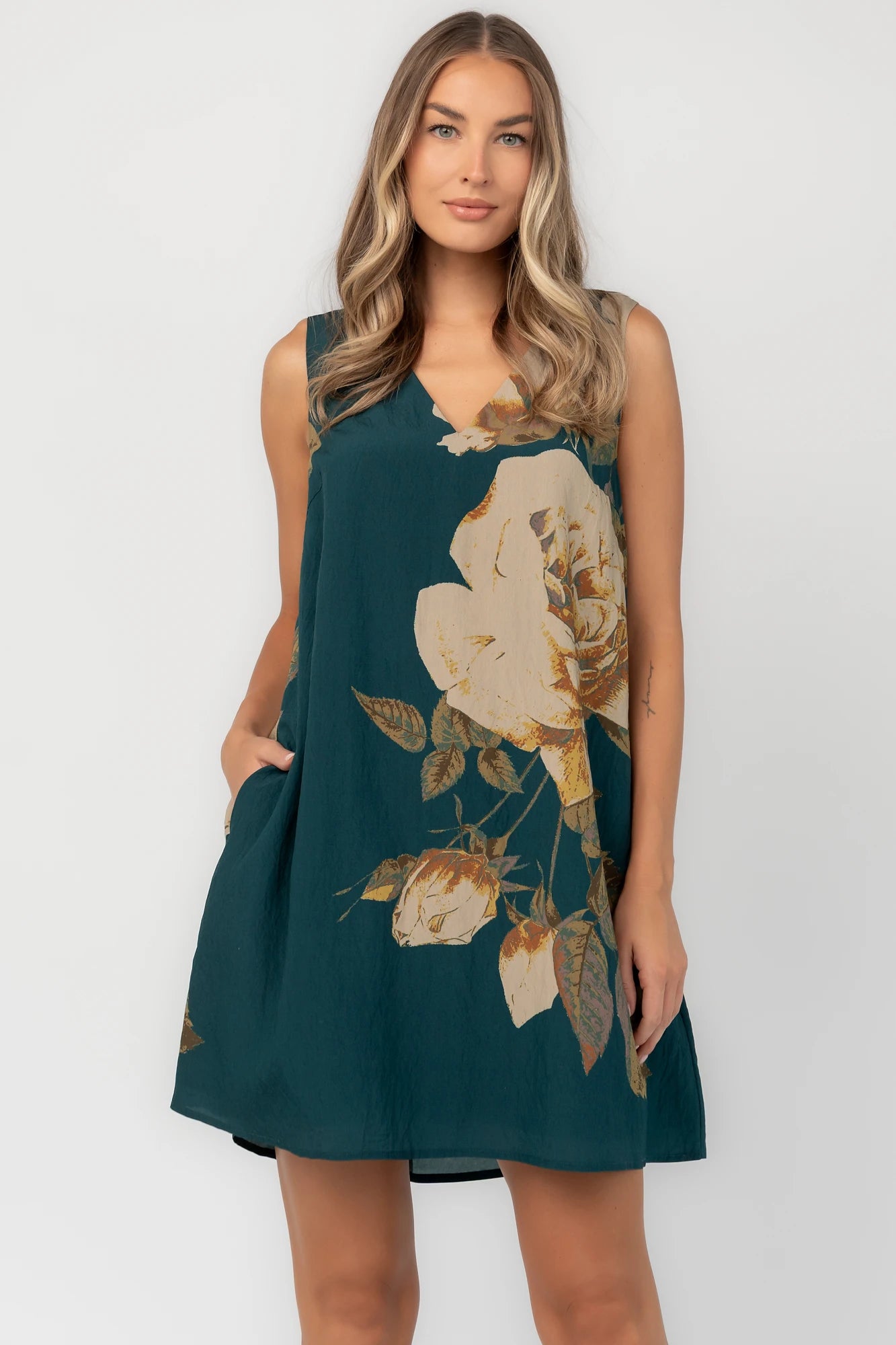 Deep topaz floral shift dress with a V-neckline, sleeveless silhouette, side pockets, and a relaxed above-the-knee fit.
