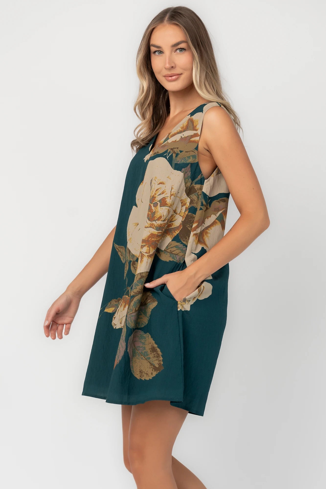 Deep topaz floral shift dress with a V-neckline, sleeveless silhouette, side pockets, and a relaxed above-the-knee fit.