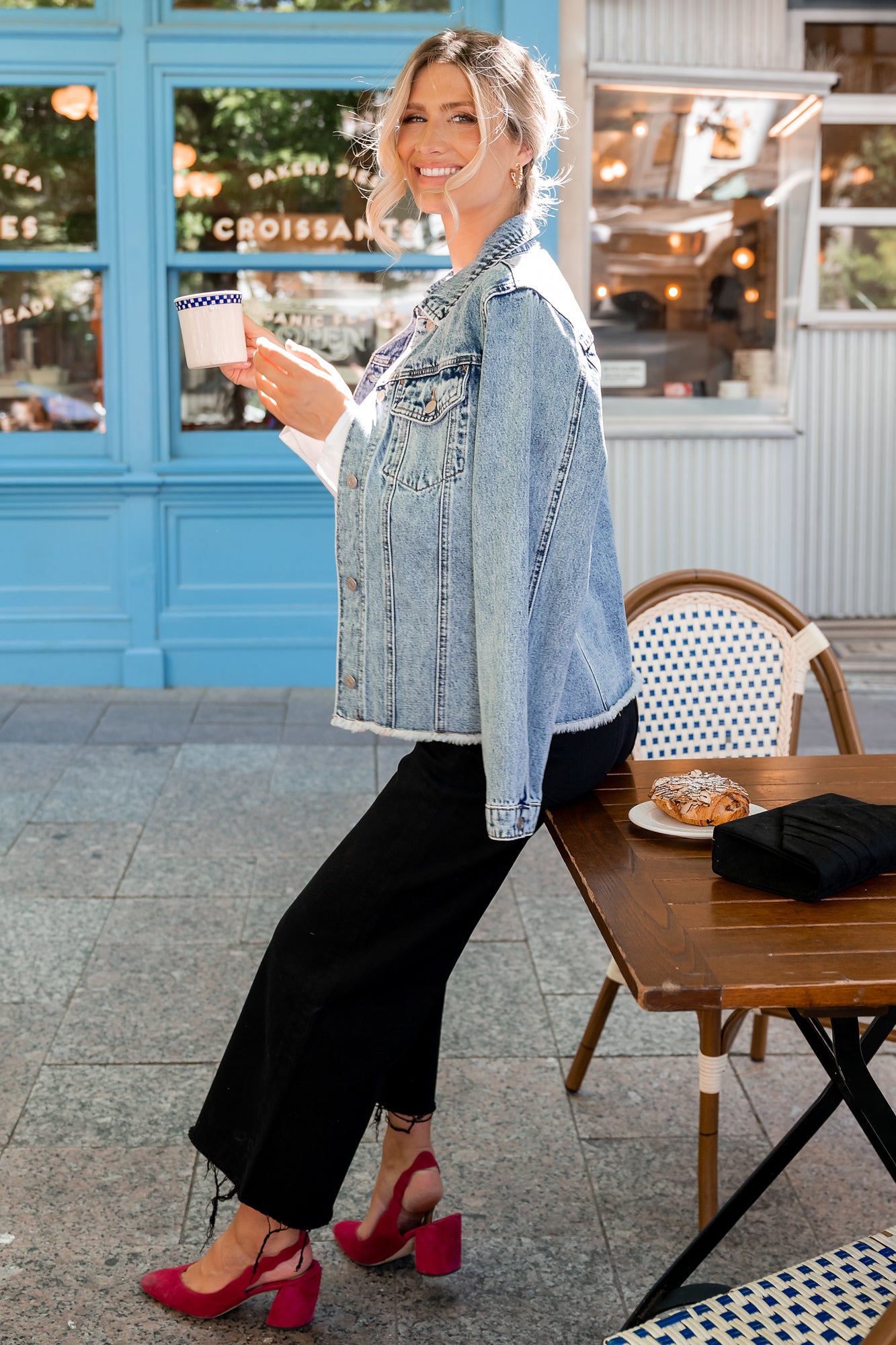 Back view of Devon denim jacket on model highlighting relaxed back silhouette and raw hem that adds casual, modern texture.