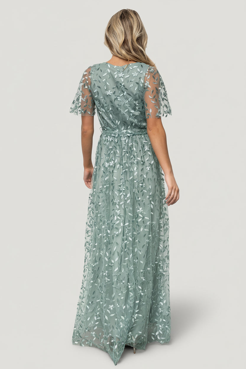 Close-up of vine-embossed organza fabric in eucalyptus, highlighting raised floral texture and semi-sheer overlay above the smooth polyester lining.