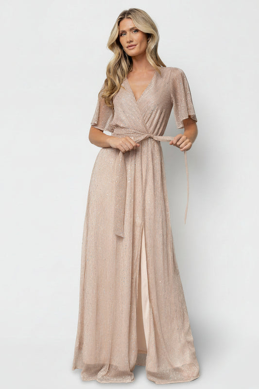 Studio shot of model wearing champagne sequin gown showing textured semi-sheer overlay, iridescent sequins and delicate sleeve detail.