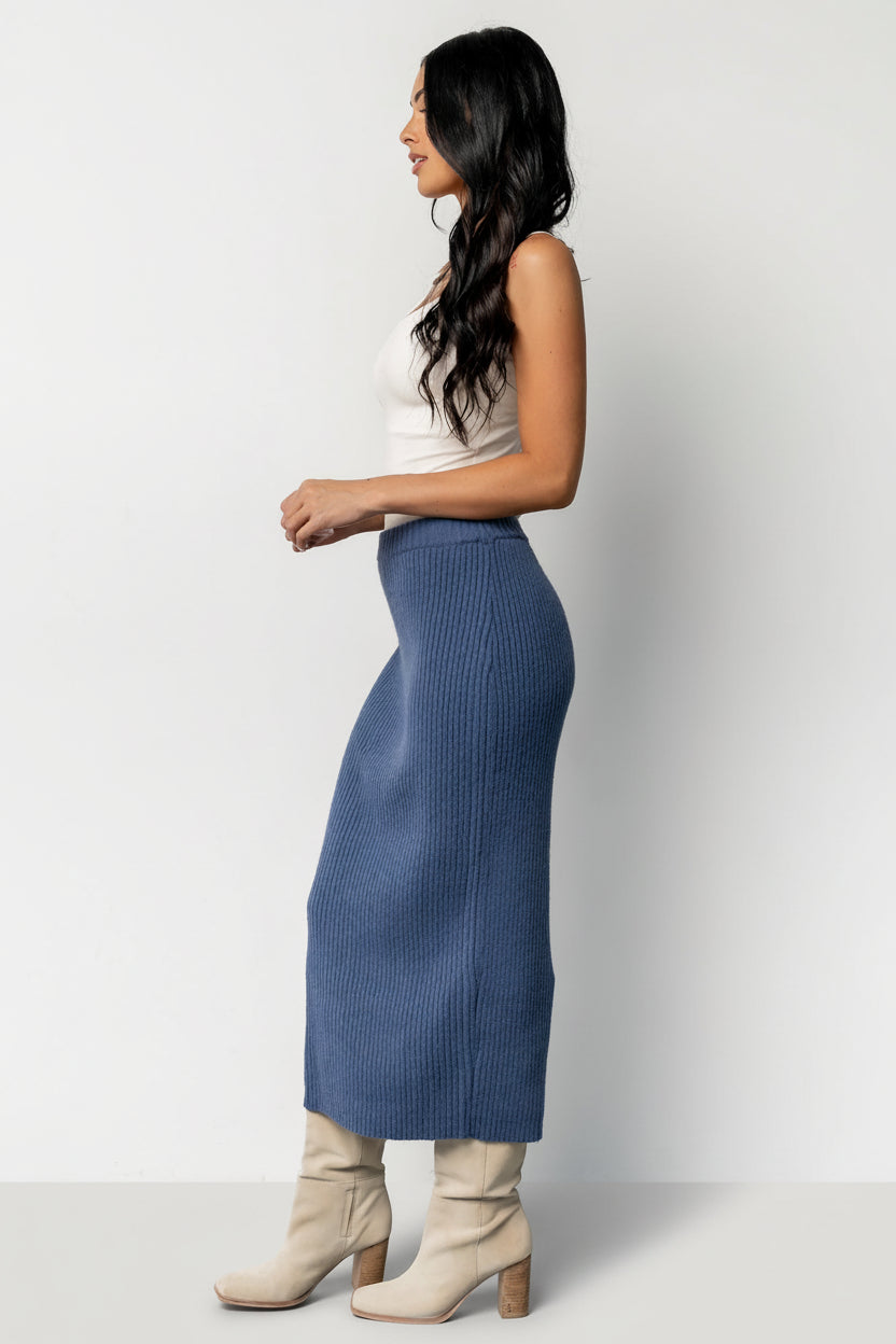 Detail image of the skirt's hem and fabric texture, showing the ribbing, unlined finish, and soft knit composition ideal for layering.