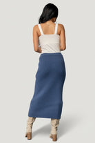 Flat lay of the blue rib knit midi skirt displaying the overall rib pattern, raw hem edge, and the gently elastic waistband for easy wear.