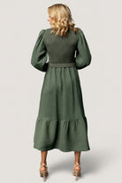 Close-up of ribbed knit bodice and square neckline of dusty-green Alva dress with visible ruffle shoulder detail and soft fabric texture.