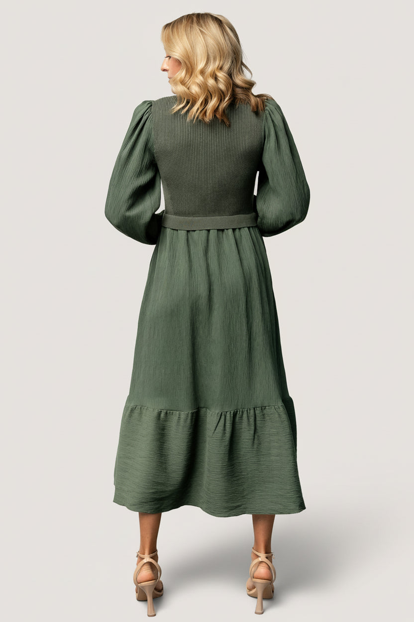 Close-up of ribbed knit bodice and square neckline of dusty-green Alva dress with visible ruffle shoulder detail and soft fabric texture.