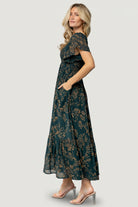 Side-angle photo showing the Monica dress’s high upturned V waistline, hidden side pocket placement, and the soft drape of the lined chiffon skirt.
