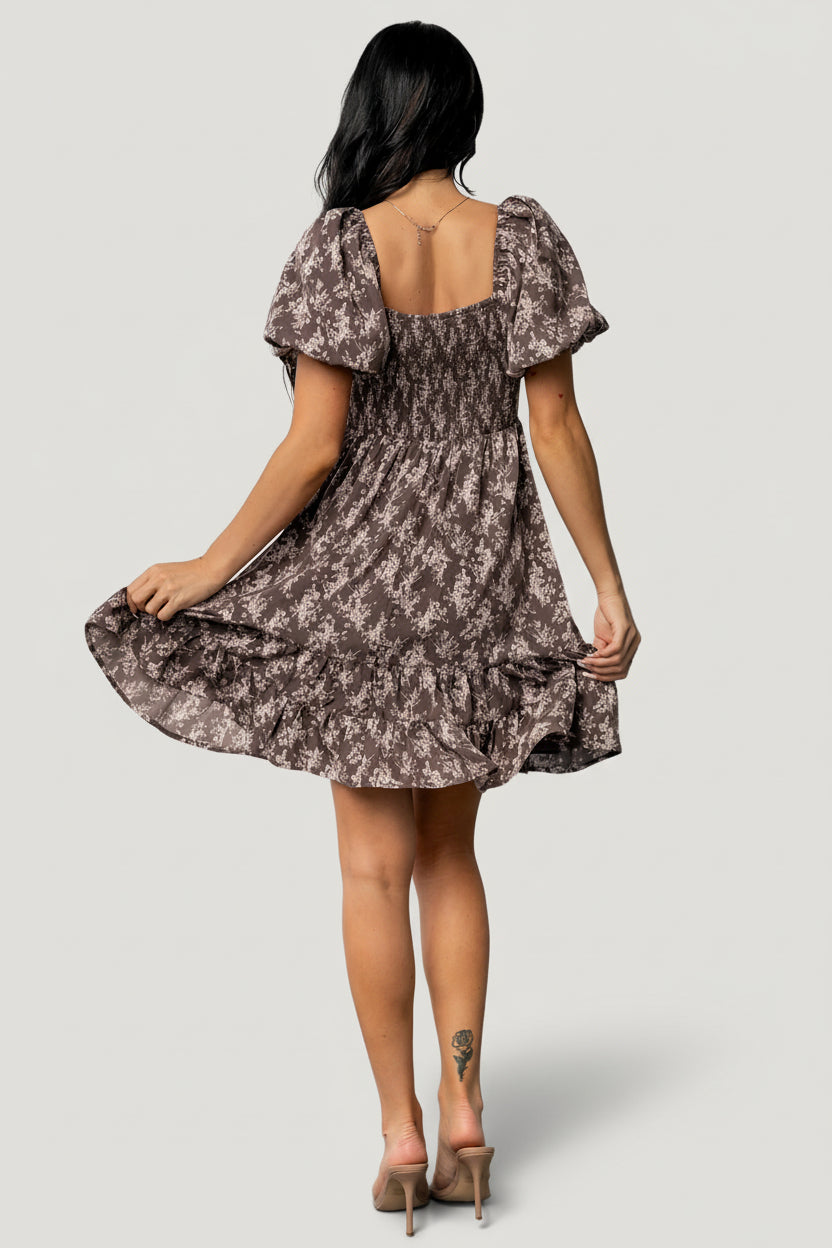 Full-length image of the Anastasia Bow Short Dress in dusty clove print styled with neutral shoes to show length and movement.