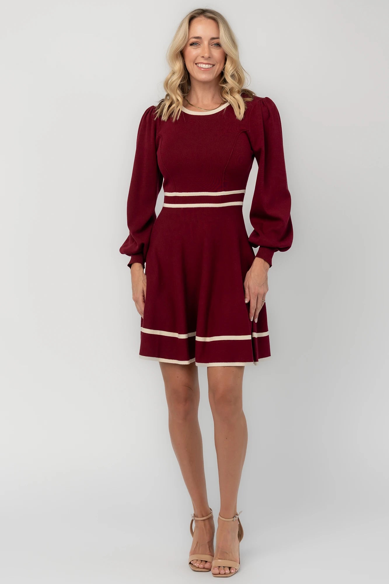 Rich wine knit mini dress with cream contrast trim, long balloon sleeves, a fitted waist, and a flared skirt.