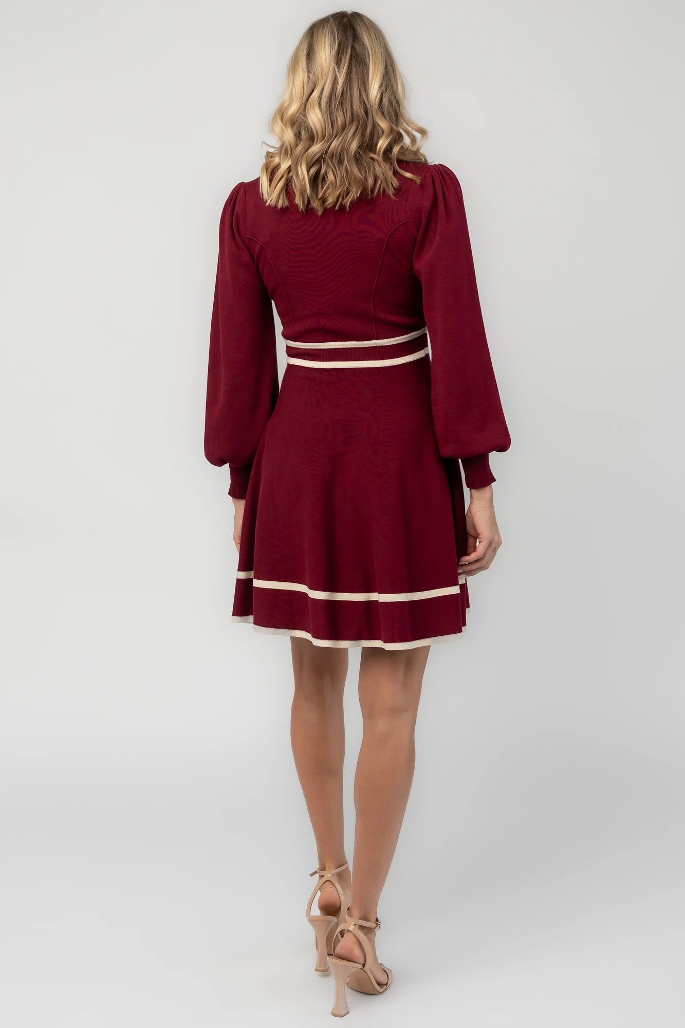 Rich wine knit mini dress with cream contrast trim, long balloon sleeves, a fitted waist, and a flared skirt.