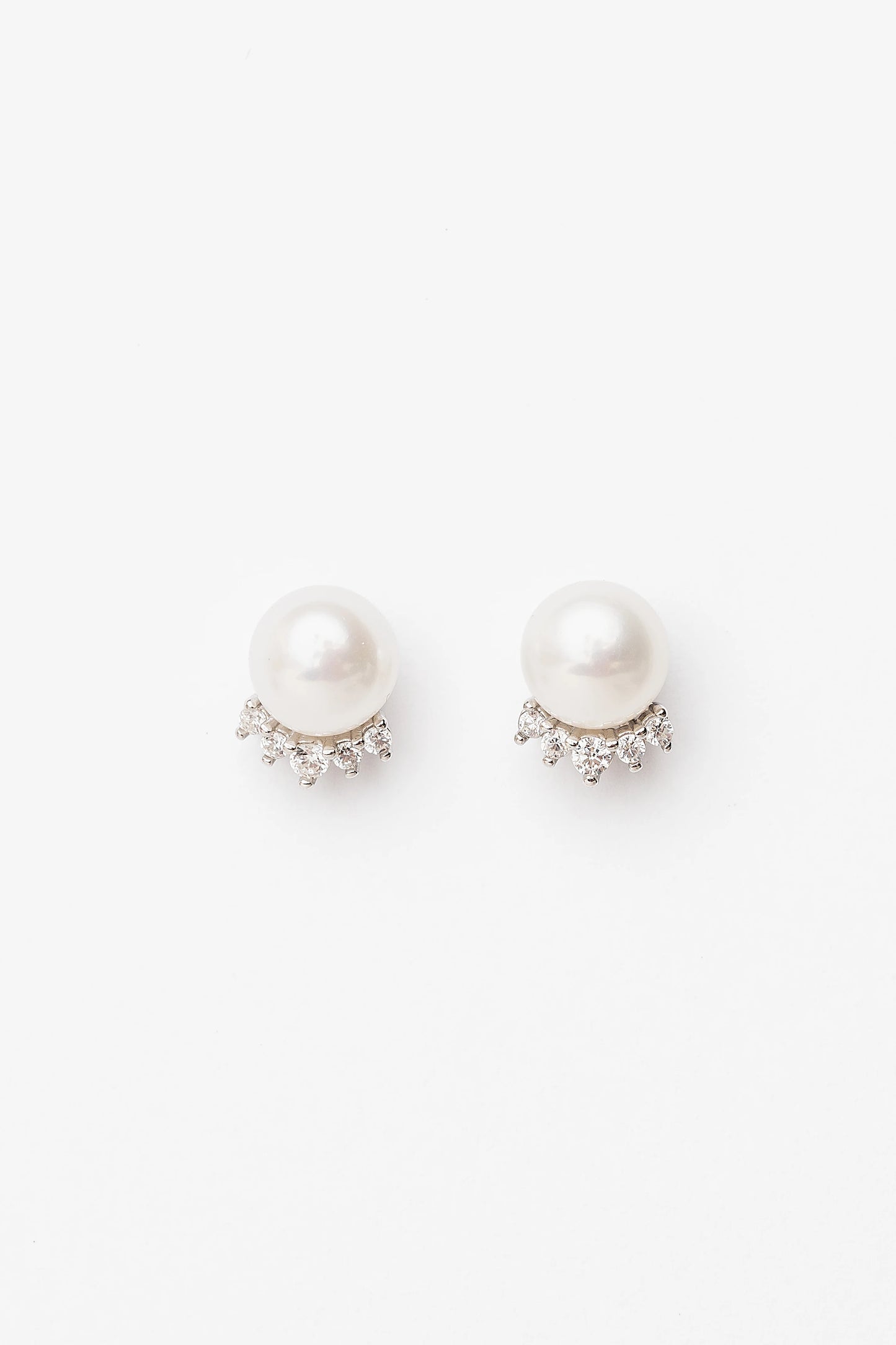 Livvy Pearl Stud Earrings with glossy pearl centers, polished sterling silver settings, and classic post backs.