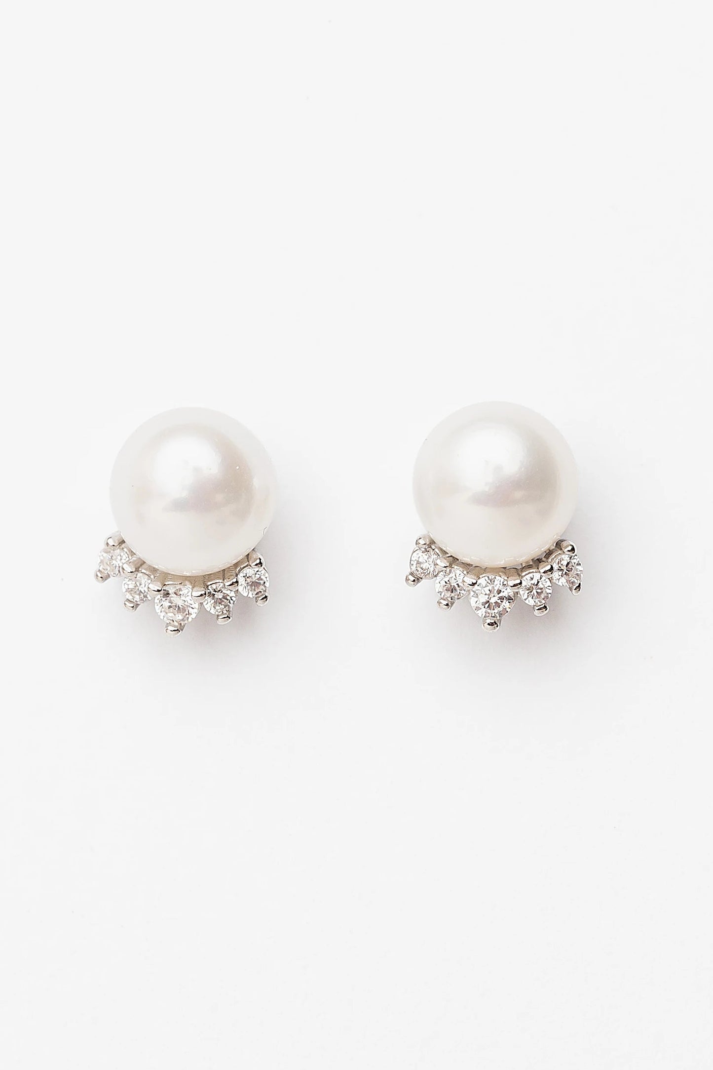 Livvy Pearl Stud Earrings with glossy pearl centers, polished sterling silver settings, and classic post backs.
