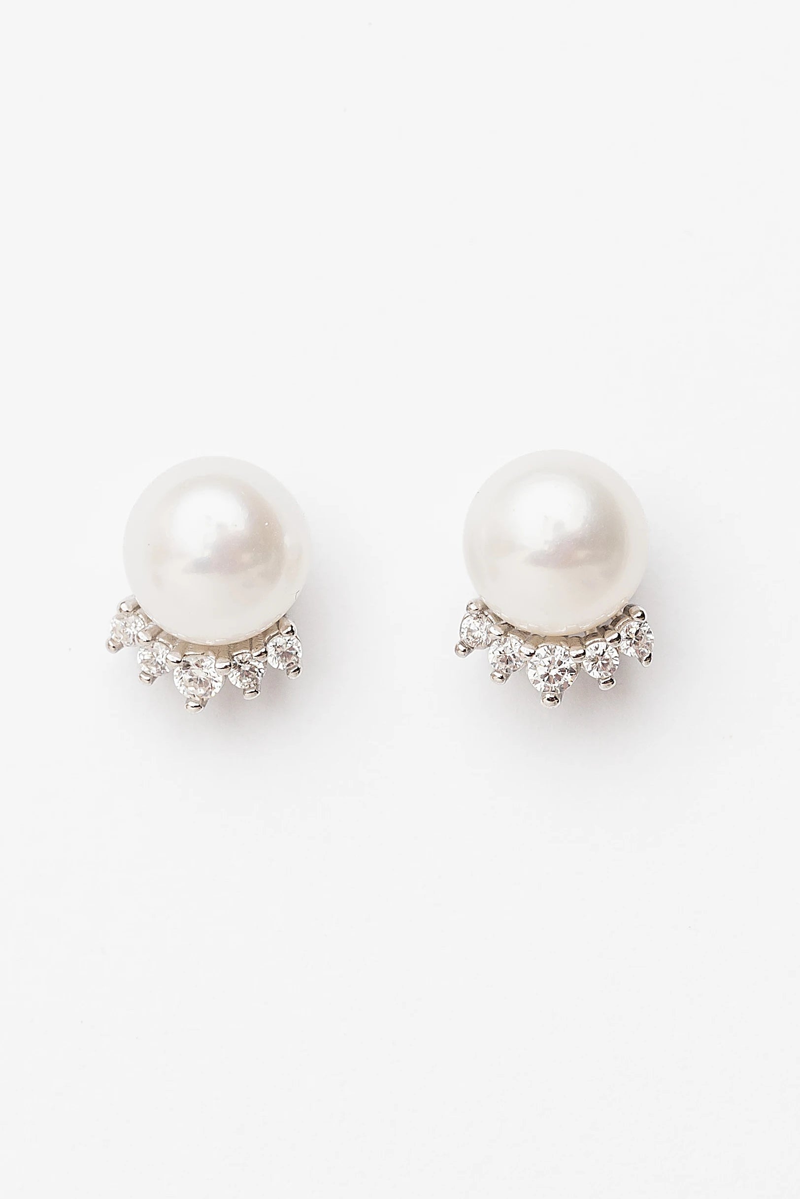 Livvy Pearl Stud Earrings with glossy pearl centers, polished sterling silver settings, and classic post backs.