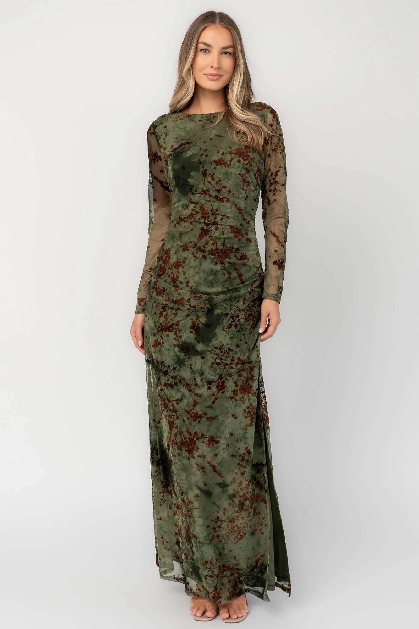 Green and rust floral mesh maxi dress with sheer long sleeves, boat neckline, and fitted silhouette.