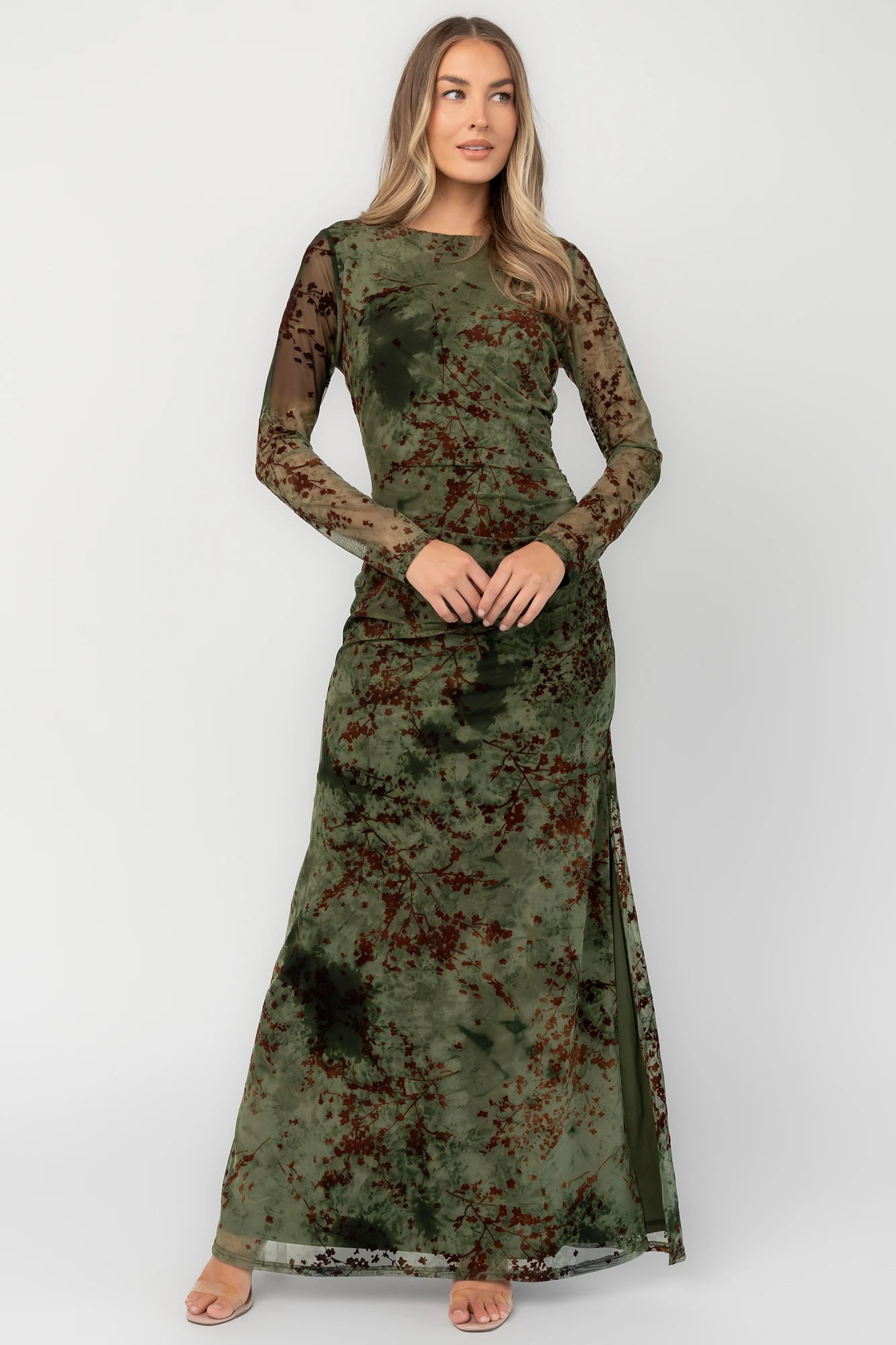 Green and rust floral mesh maxi dress with sheer long sleeves, boat neckline, and fitted silhouette.