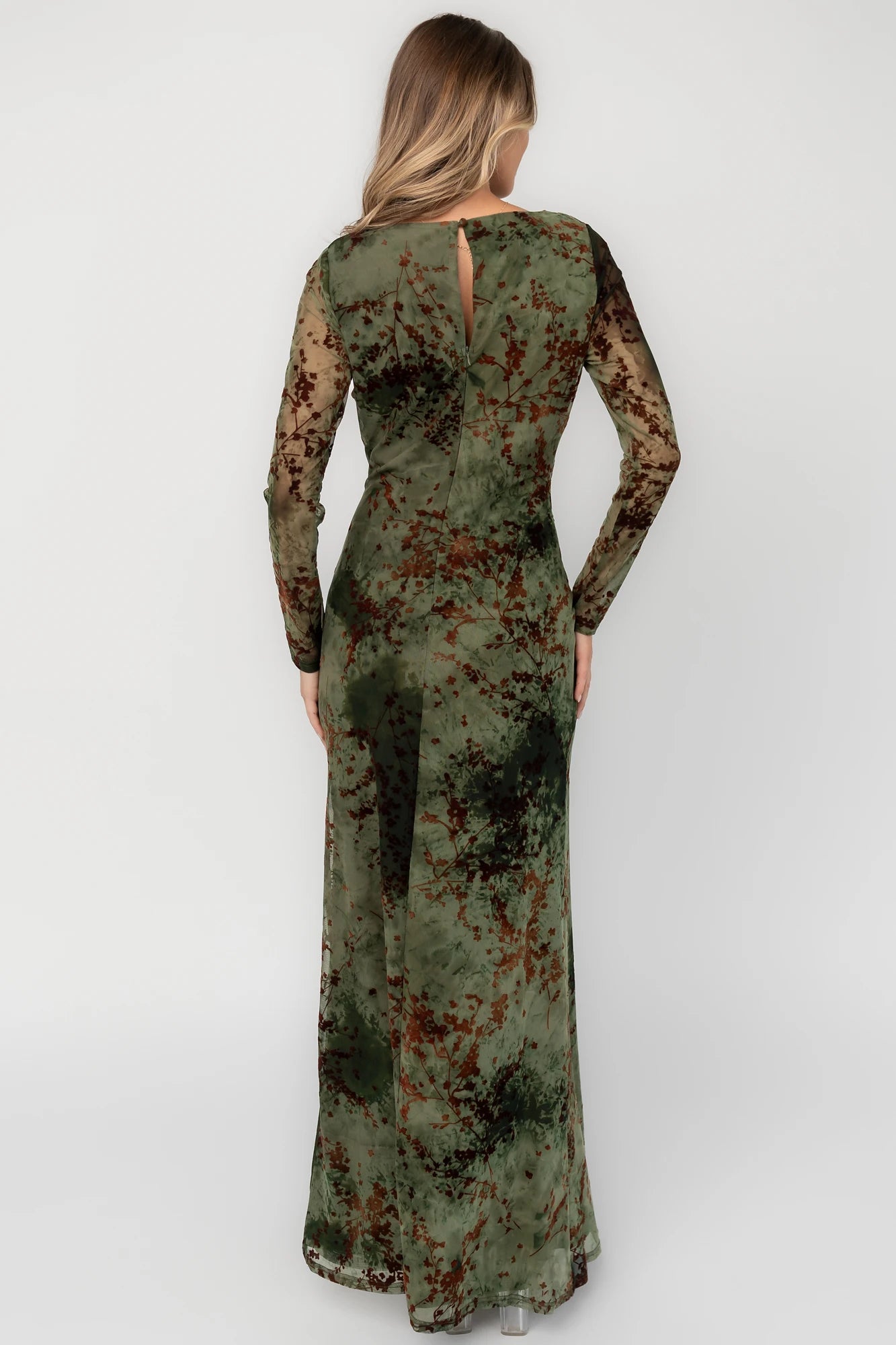 Green and rust floral mesh maxi dress with sheer long sleeves, boat neckline, and fitted silhouette.