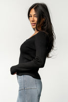 Close-up of ribbed fabric and decorative henley-style buttons on the Leo Top in black, showing knit texture and button detail.