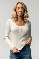 Flat-lay and folded view of the Leo ribbed henley top in ivory, highlighting the ribbed hem, button placket, and lightweight knit construction.