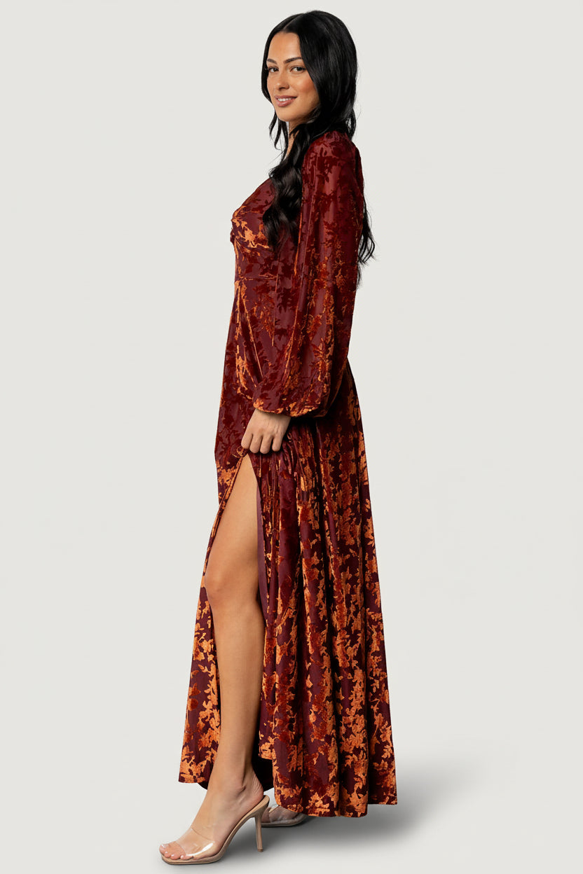 Back view of the Aurora Velvet Maxi Dress highlighting the smocked back, elastic at shoulder and cuff, and the gown's full-length silhouette.