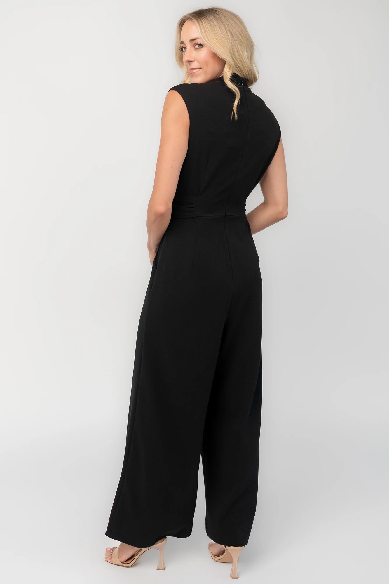 Black tailored wide-leg jumpsuit with a mock neckline, cap sleeves, removable tortoise buckle belt, and side pockets.