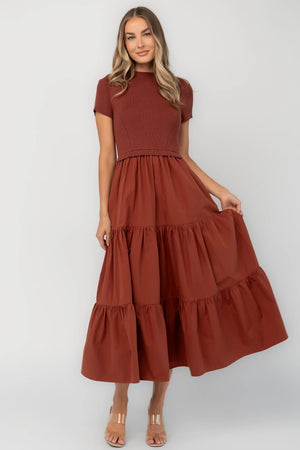 Midi dress with a ribbed knit bodice, round neckline, short sleeves, elastic waist, tiered woven skirt, and side pockets.