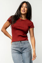 Styled flat-lay of the Penny Pointelle top in brick, highlighting scalloped edges, lightweight knit, and warm brick color.
