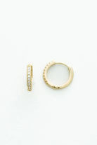 Gold-tone huggie hoop earrings accented with a row of sparkling crystal stones along the front. 