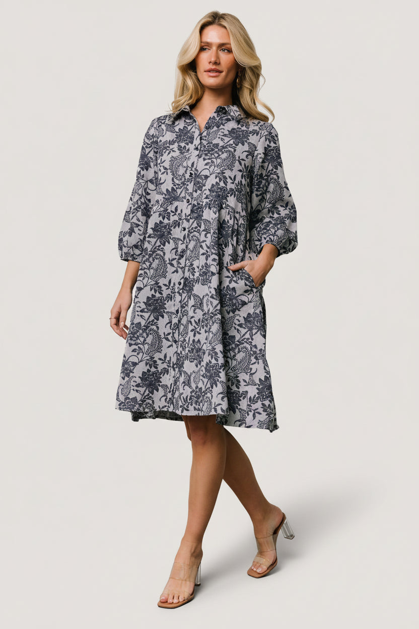 Side view of the Dakota dress showing tiered skirt movement, side pockets and relaxed silhouette in navy botanical print.