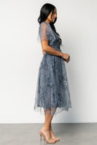 Full-length photo of Josie Tulle Midi Dress in dusty blue floral in motion, highlighting the flowy midi skirt and feminine silhouette.