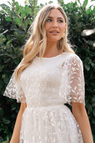 Close-up of floral embroidery and double-layer tulle texture on the Kendra white midi dress, highlighting stitch detail.
