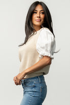 Studio detail image of the Taylor Puff Sleeve Top showing knit texture, contrast sleeve fabric and round neckline at close range.
