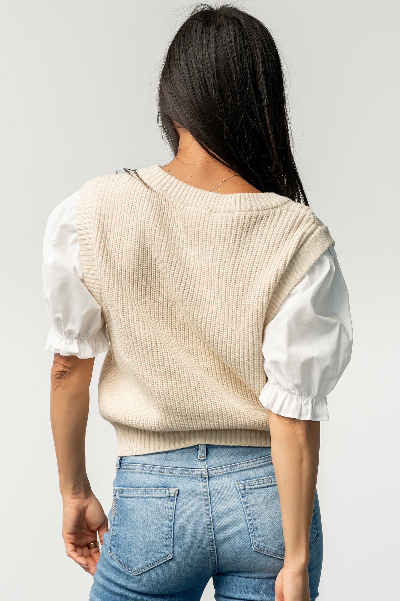 Styled outfit photo: Taylor Puff Sleeve Top paired with mid-rise bootcut jeans, showing how the vest layers for a casual polished look.