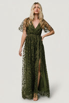 Front view of olive Marseille maxi dress showing vine-embossed organza, surplice neckline, elastic waist, and left-side slit for movement.