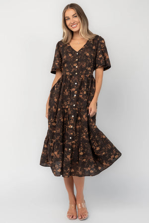 Clove floral midi dress with a V-neckline, functional button-front closure, puff sleeves, elastic back waist, side pockets, and a tiered skirt.
