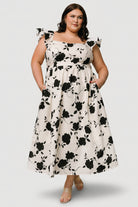 Close-up of dress fabric and print: ivory ground with contrasting black floral motifs and textured cotton weave.