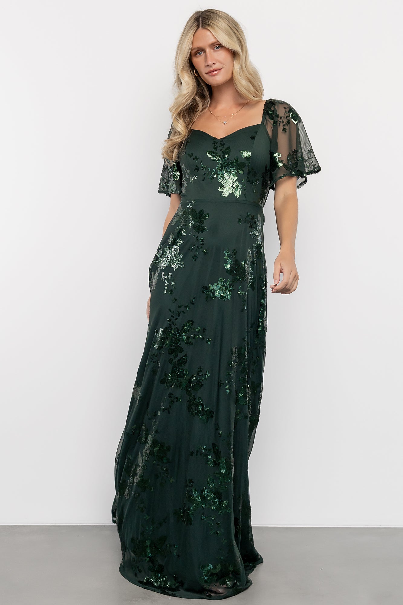 Styling shot of the Karina dress in motion, full-length view capturing the skirt's movement and sequin shimmer under studio lighting.